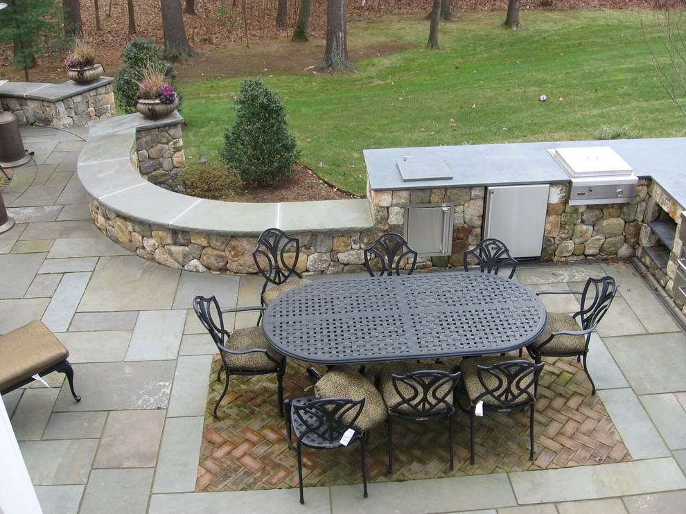 patio with stone wall and grill