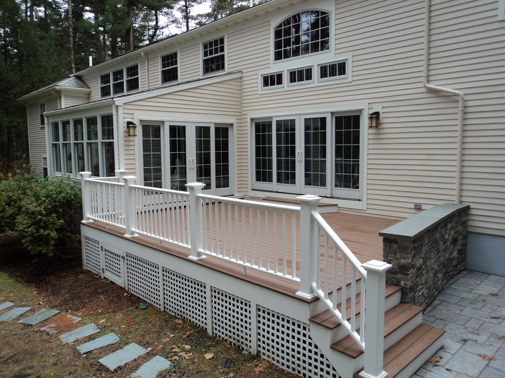 deck with wood railings and stone wall